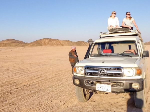 A-wonderful-shot-of-two-girls-sitting-on-a-four-wheel-drive-vehicle-from-a-safari-trip